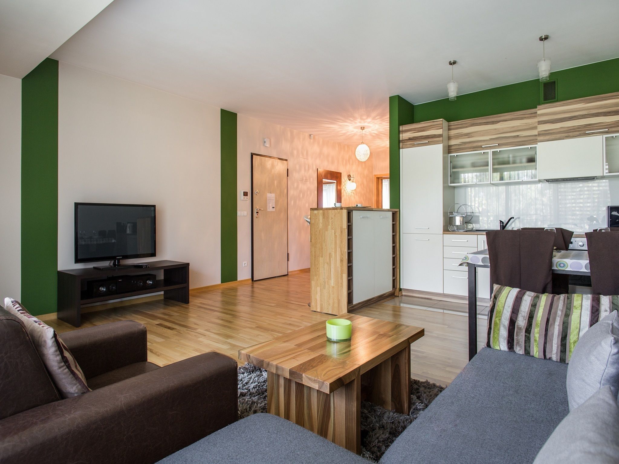 A modern living room with a TV, sofa, and wooden coffee table.