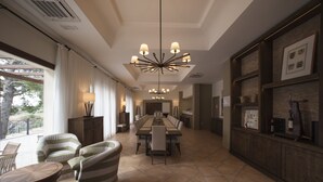 Un comedor amplio con una mesa larga, varias sillas y una lámpara moderna.