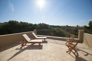 A terrace with two wooden lounge chairs and a tiled floor. - Feudo del Biviere (Santa Ninfa)