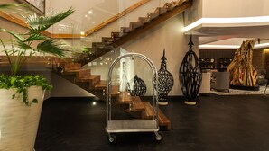 A modern interior with a staircase, a clear glass elevator, and a potted plant. - Square Small Luxury Hotel - Nuevo Consulado (Guadalajara)