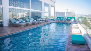 A modern pool area with lounge chairs and a view of the city. - Square Small Luxury Hotel - Nuevo Consulado (Guadalajara)