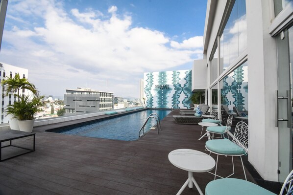 A rooftop pool area with a view of the city, lounge chairs, and a bar area. - Square Small Luxury Hotel - Nuevo Consulado (Guadalajara)