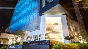 The exterior of the Square Mall Luxury Hotel with a modern glass facade and illuminated signage. - Square Small Luxury Hotel - Nuevo Consulado (Guadalajara)