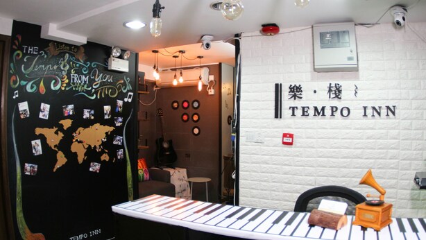 A room with a world map on the wall, a piano, and a sign reading "TEMPO INN". - Tempo Inn West Kowloon HSR Station (Kowloon)
