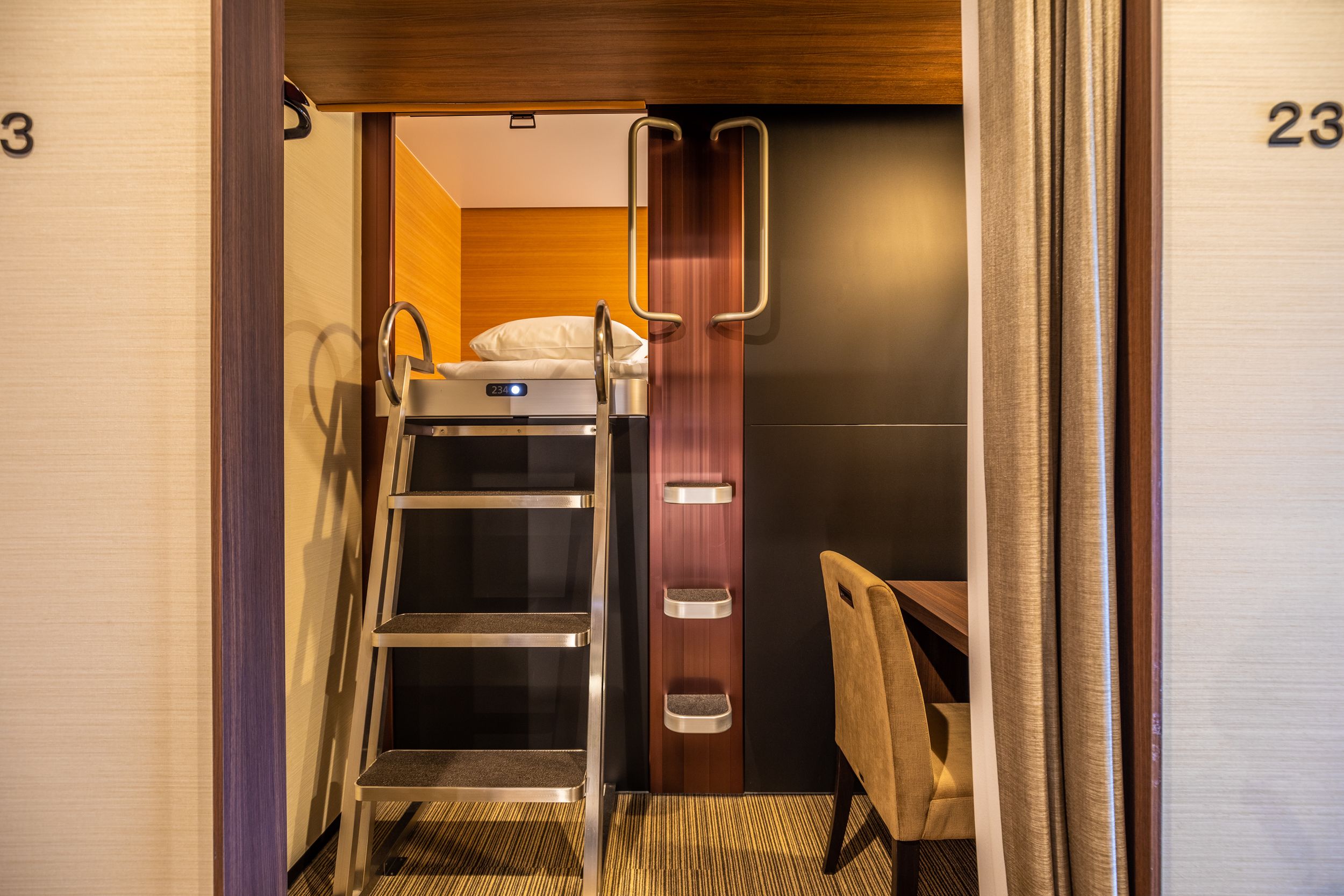 A compact hotel room with a bunk bed, a small desk, and a chair.