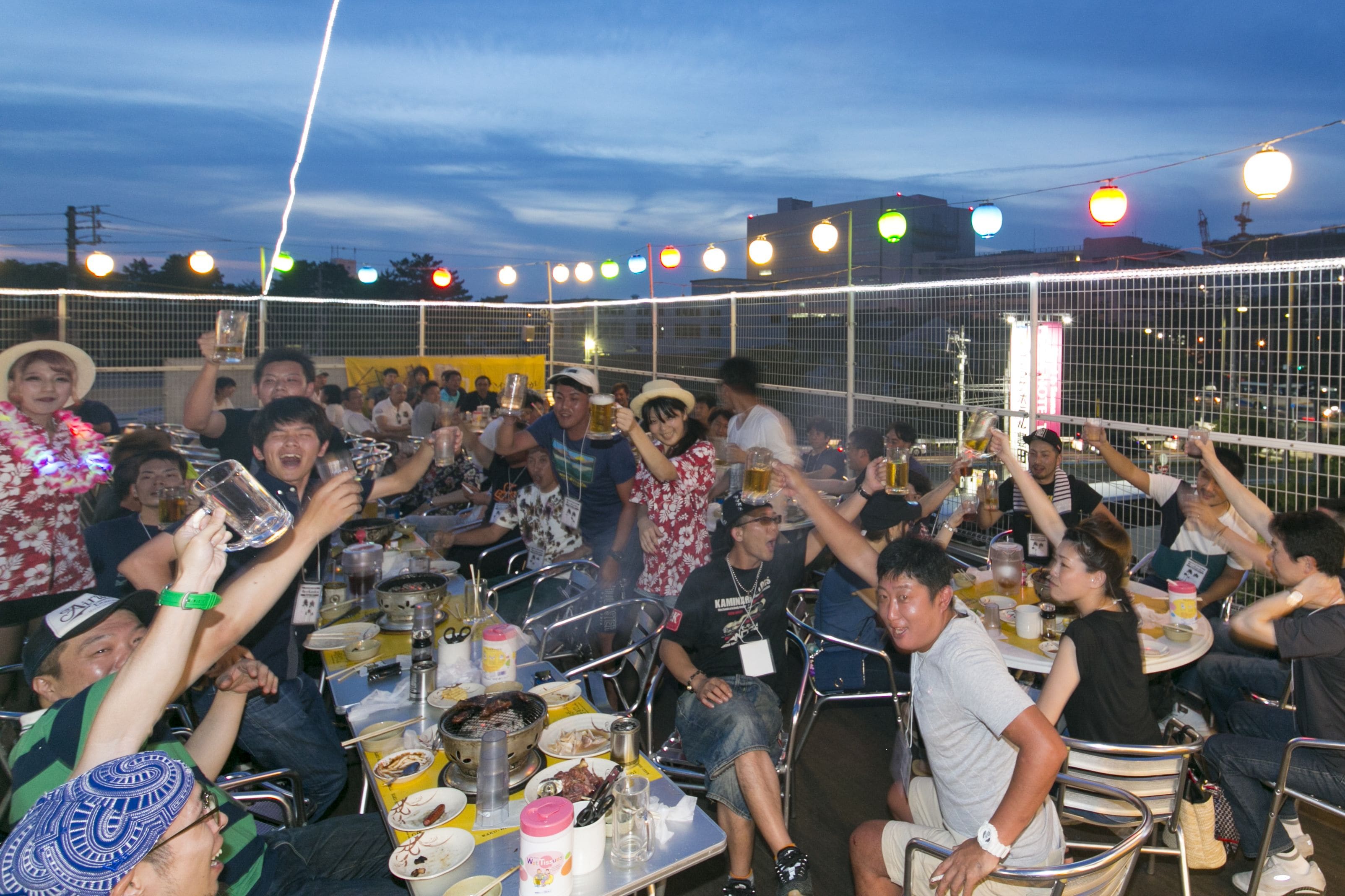 A group of people gathered around tables with food and drinks, celebrating.