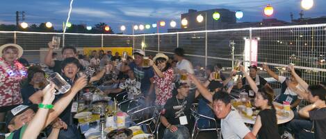 A group of people gathered around tables with food and drinks, celebrating.