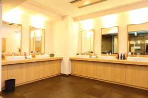 Een moderne badkamer met twee wastafels, spiegels en houten kastjes.