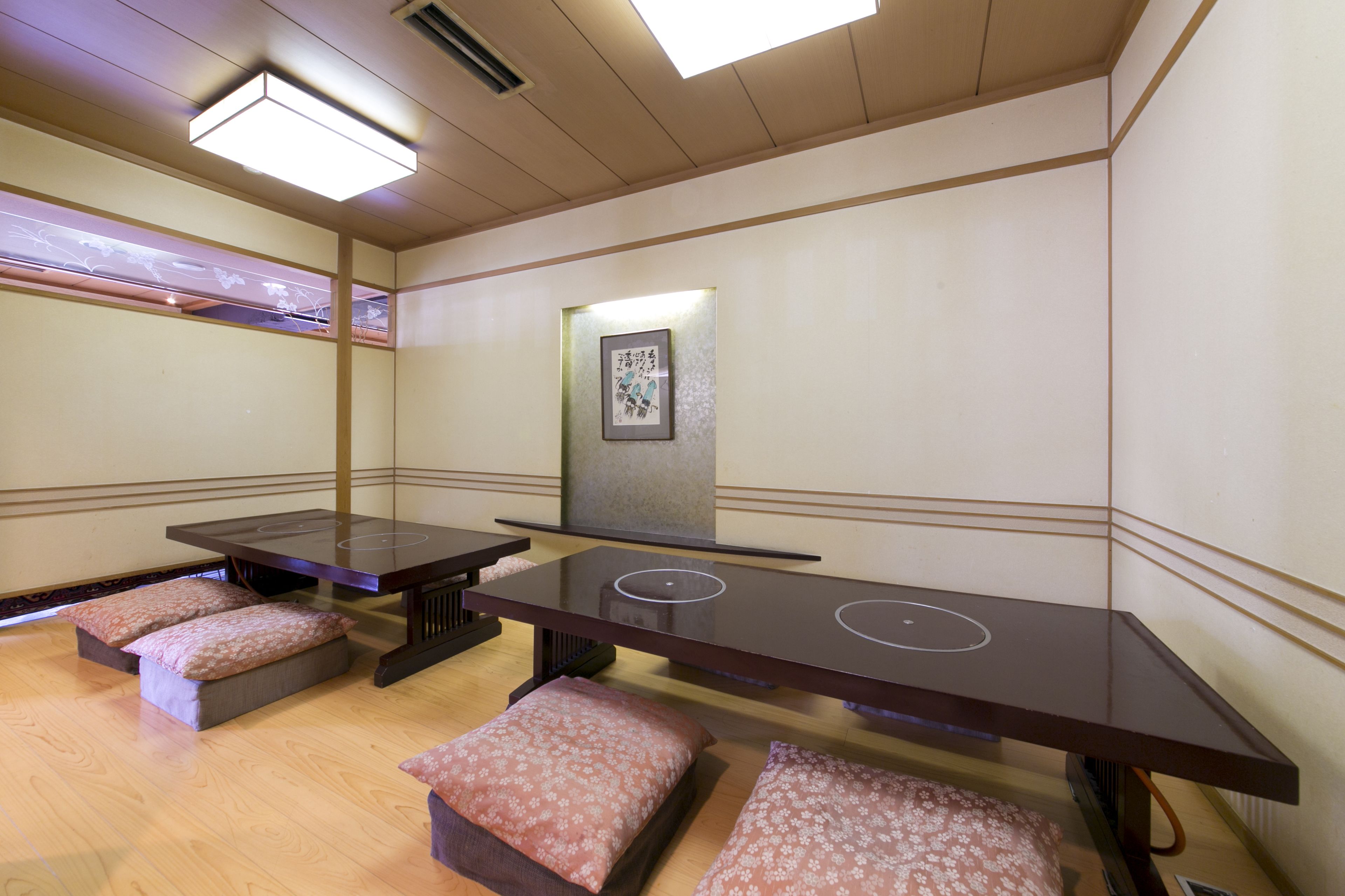 A room with two massage tables, each with a pillow and a small bench.