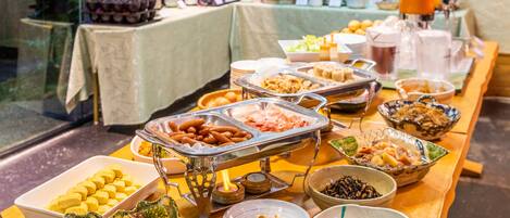 A buffet with various food items and a coffee station.