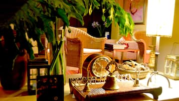 A cozy room with wicker furniture, a clock, and a decorative tray with items.