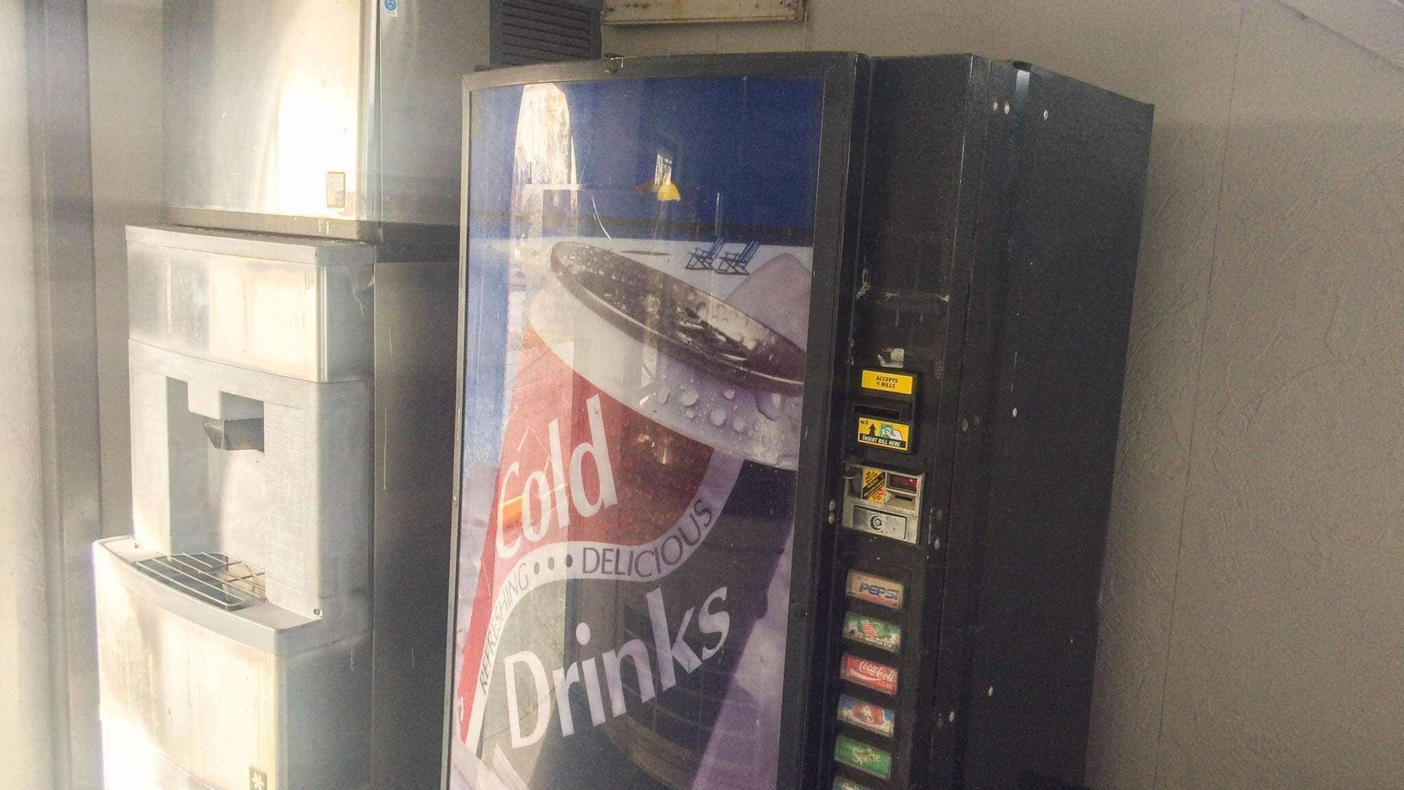 Máquina expendedora con publicidad de Coca-Cola para bebidas frías.