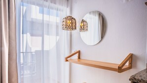 Una habitación con una estantería de madera, un espejo redondo y una lámpara.