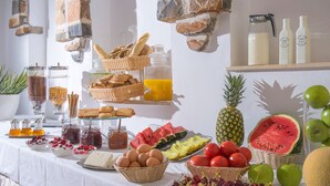 Un bufé de desayuno con diversas frutas, pan y bebidas.