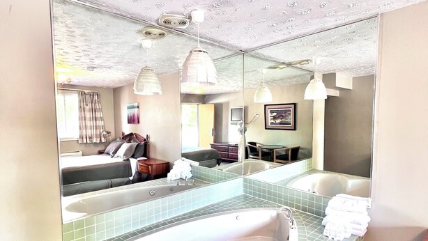 Ein Badezimmer mit einem großen Spiegel, einer freistehenden Badewanne und einem Waschtisch.