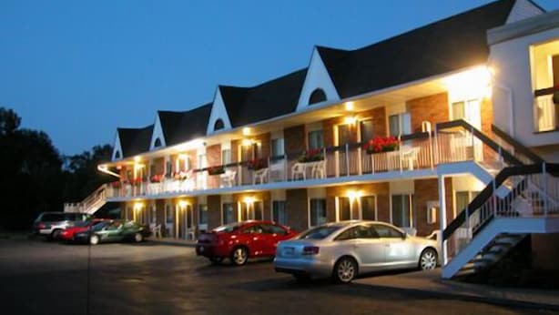 Un motel à étages, doté d’un parking couvert et d’un escalier menant à l’entrée.