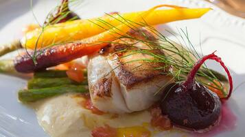 Un plat blanc amb un tros de peix, espàrrecs i una remolatxa.