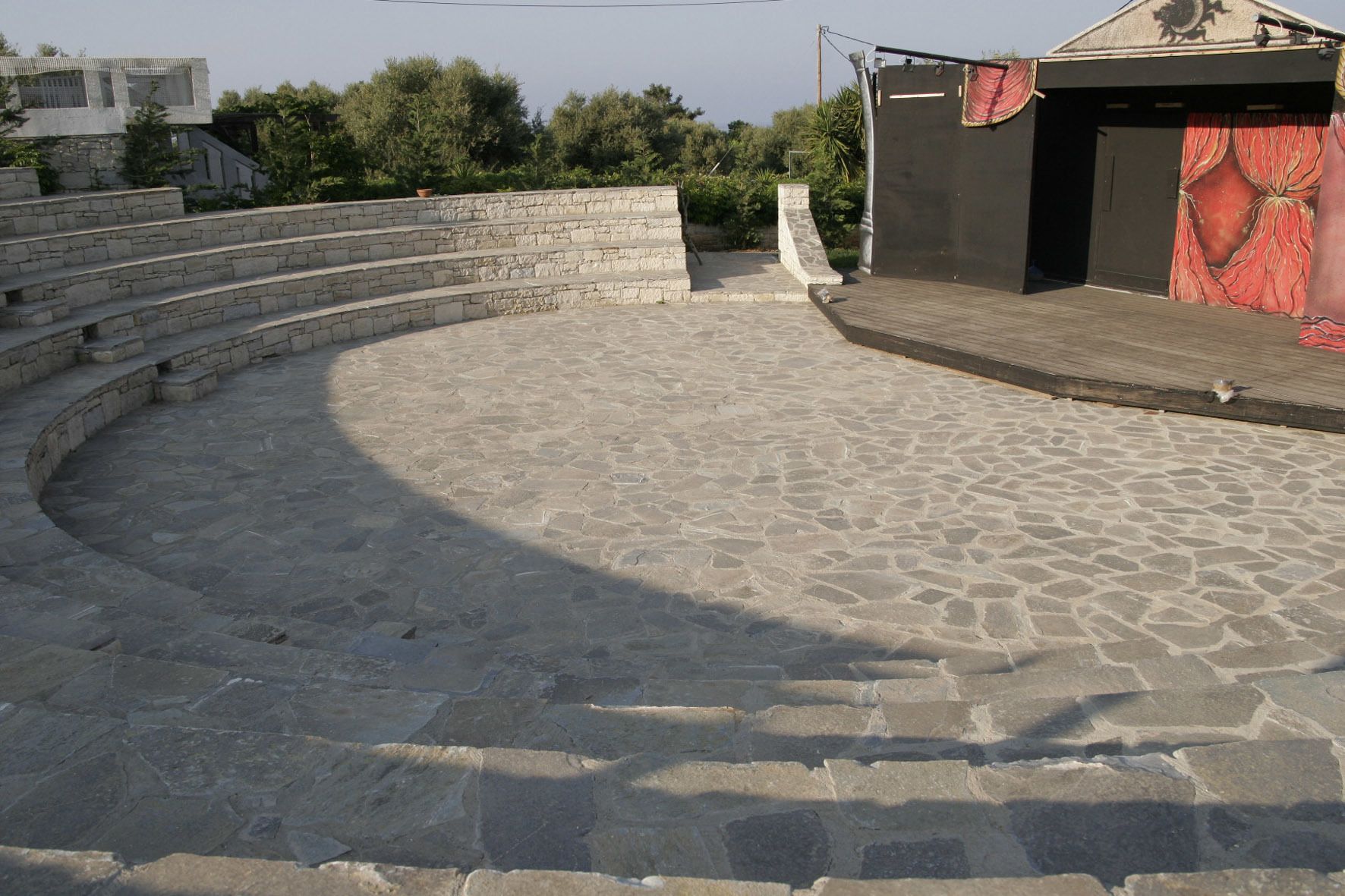 A stone amphitheater with tiered seating and a stage area.