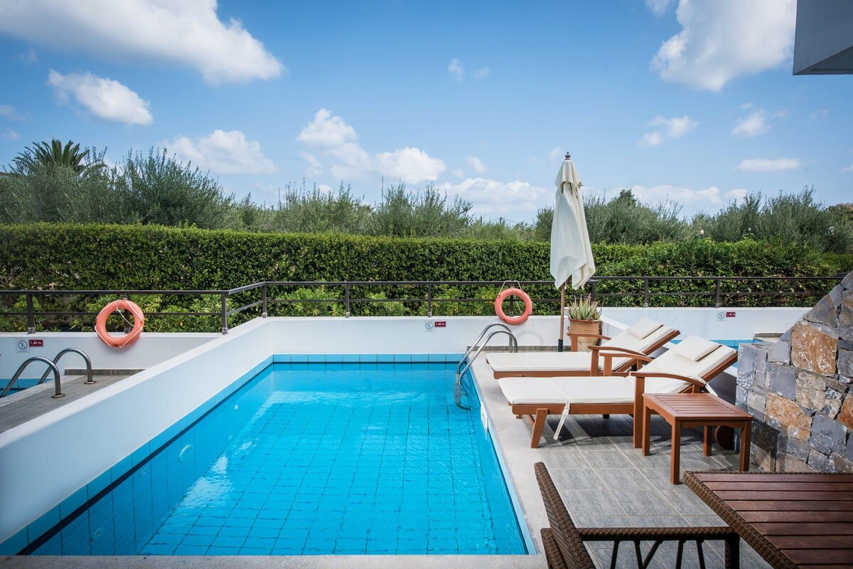 A rooftop swimming pool with lounge chairs and a lifebuoy.