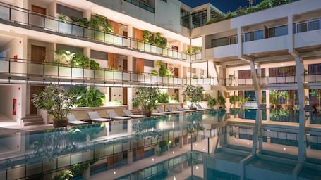 Una piscina al aire libre, camas de piscina gratis, sombrillas