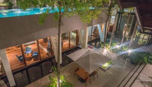 Un espace extérieur moderne, aménagé en terrasse, avec une piscine, un revêtement de sol en bois et des coins salon.