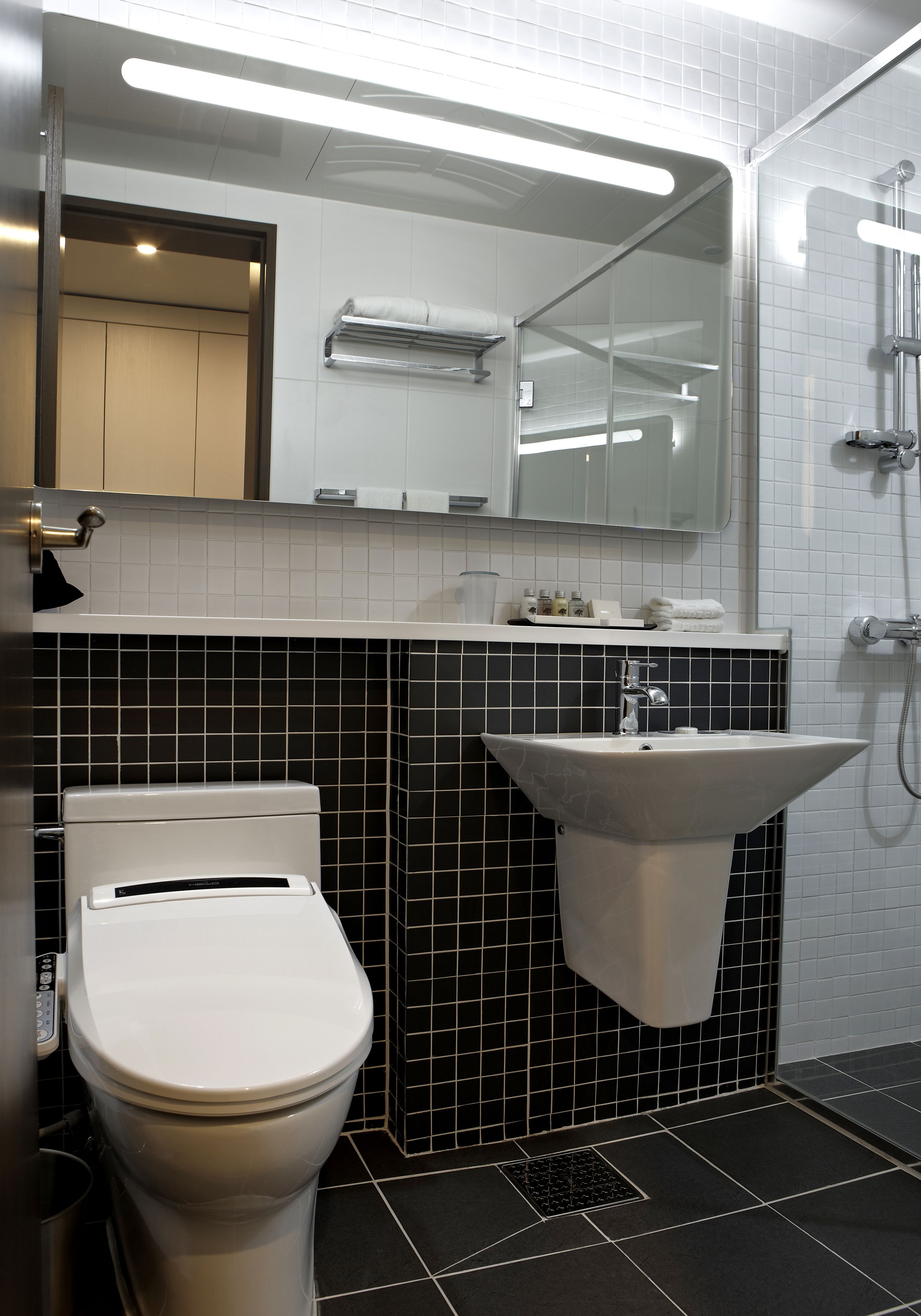 A modern bathroom with a toilet, sink, and shower.