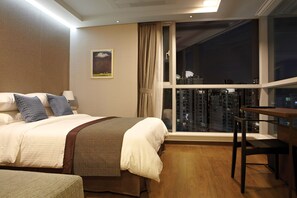 A hotel room with a bed, a desk, and a view of a cityscape through a large window. - Ocloud Hotel Gangnam (Seoul)