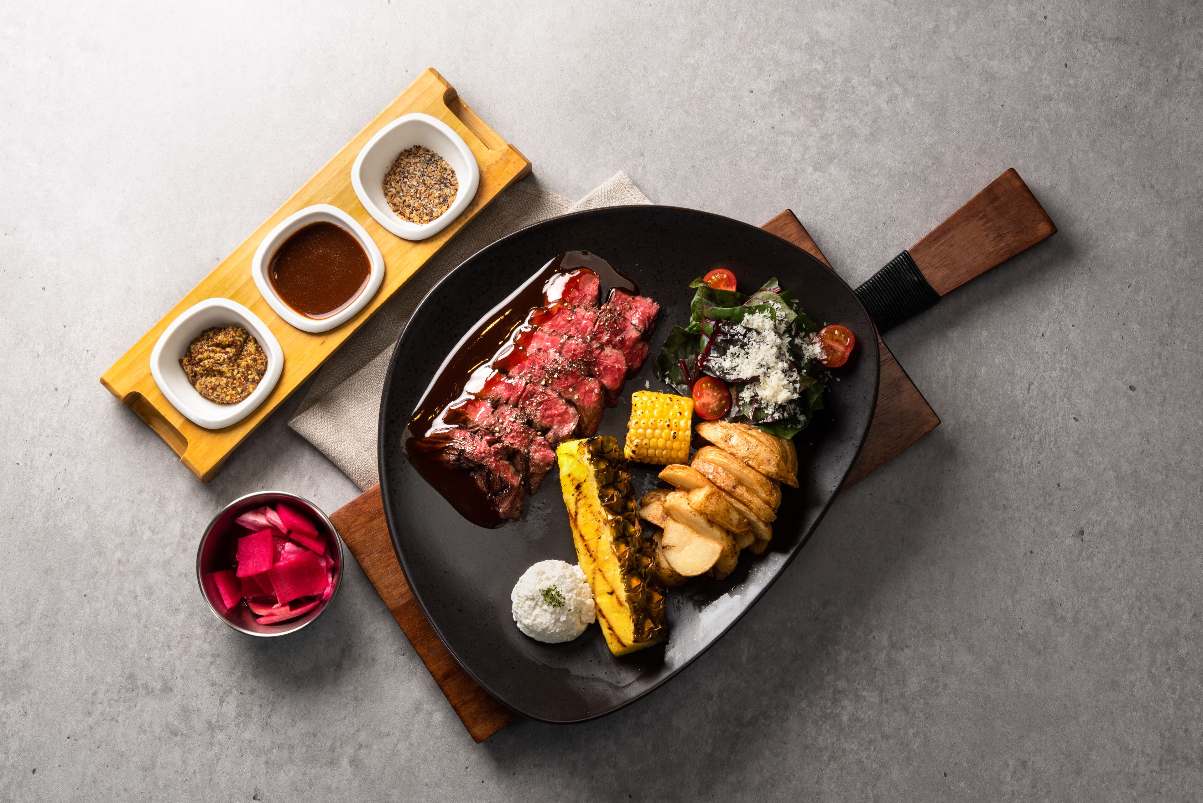 Ein Teller mit einem Steak, Gemüse und Soßen.