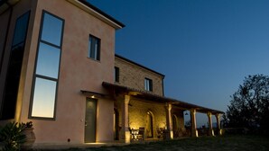Una casa moderna de dos pisos con ventanas amplias y un patio cubierto.
