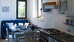 Una cocina compacta con comedor, techo de madera y ventana que deja entrar luz natural.