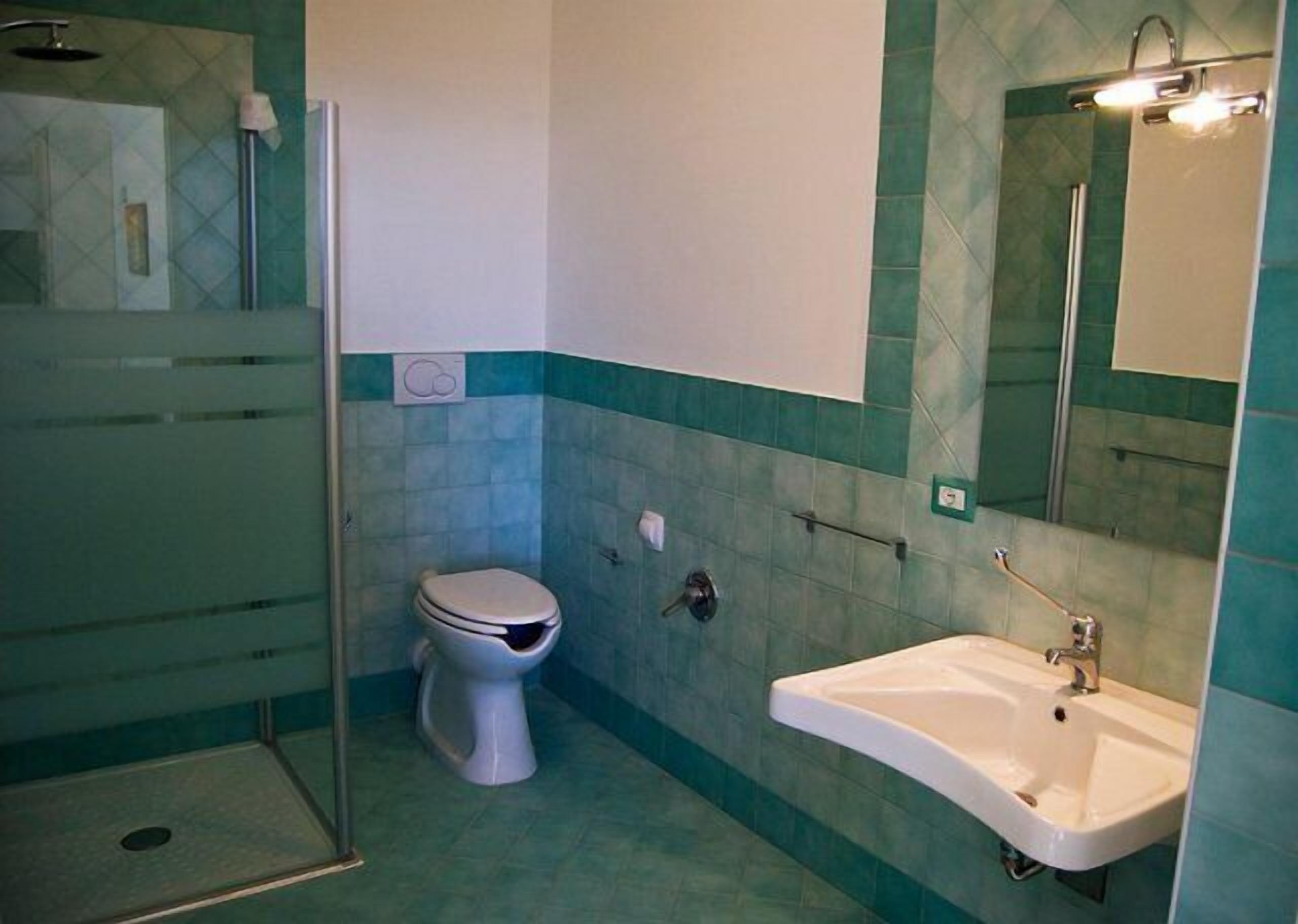 Une salle de bain avec des toilettes, un lavabo et une douche.