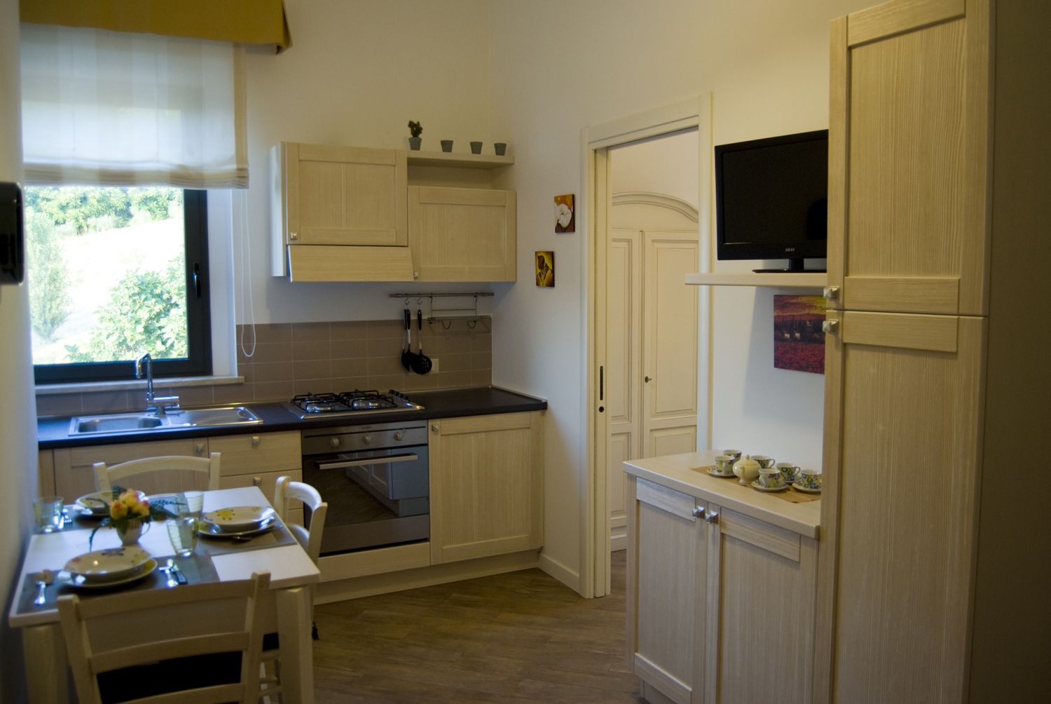 A kitchen with wooden cabinets, a stove, and a dining table with chairs.
