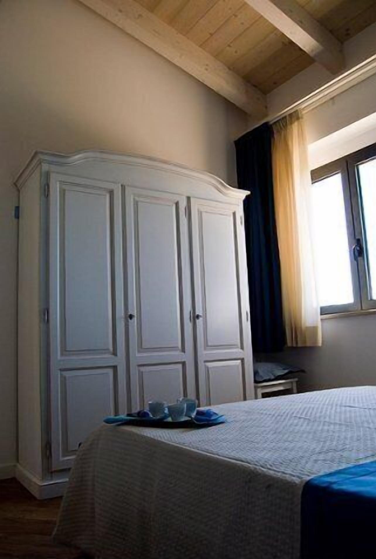 Een slaapkamer met een bed, een kledingkast en een raam met gordijnen.