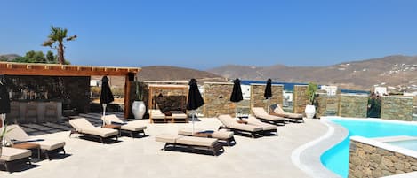 Piscine extérieure, parasols de plage, chaises longues