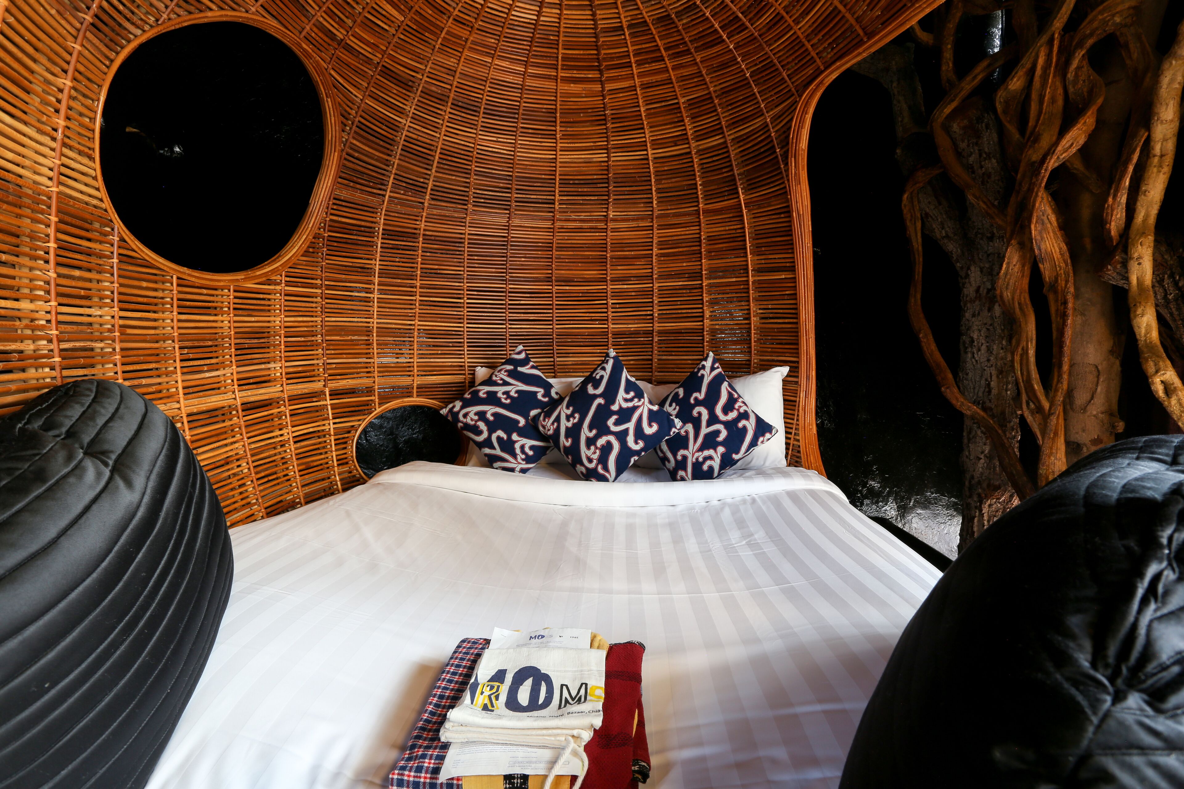 A circular room with a bed, pillows, and a small table with items.