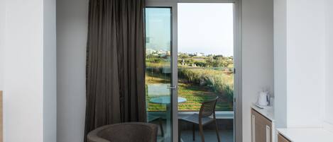 A modern room with a sliding glass door leading to an outdoor area with a table and chairs.