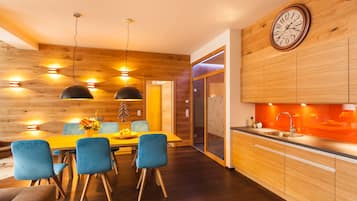 Eine moderne Küche mit Holzschränken, einem eingebauten Backofen und einem großen Fenster.