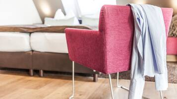 Una silla roja con patas de metal y una chaqueta azul claro colgada sobre ella.