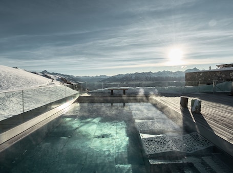 Una piscina al aire libre, sombrillas, sillones reclinables de piscina