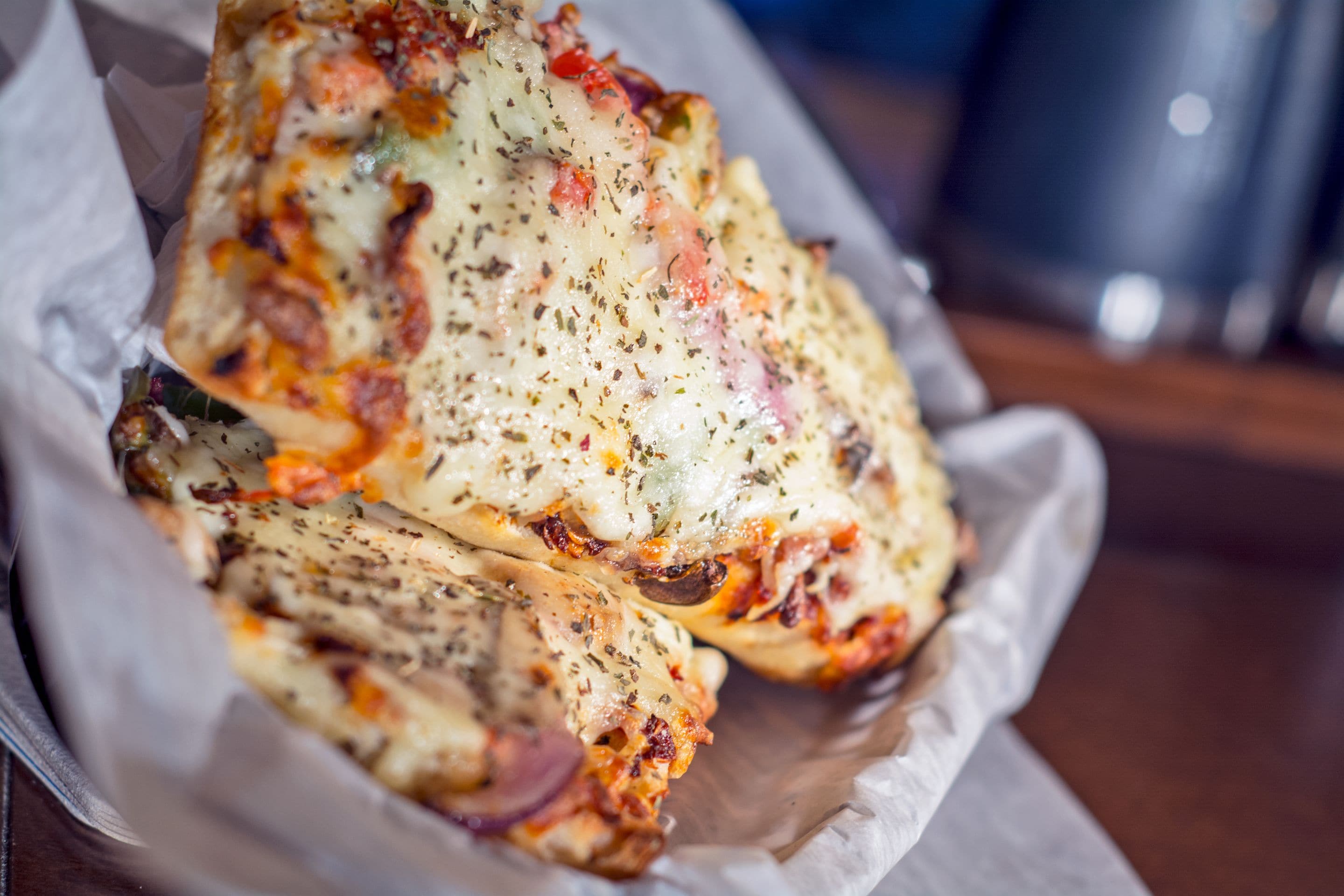 A tray of baked dishes with melted cheese and herbs.