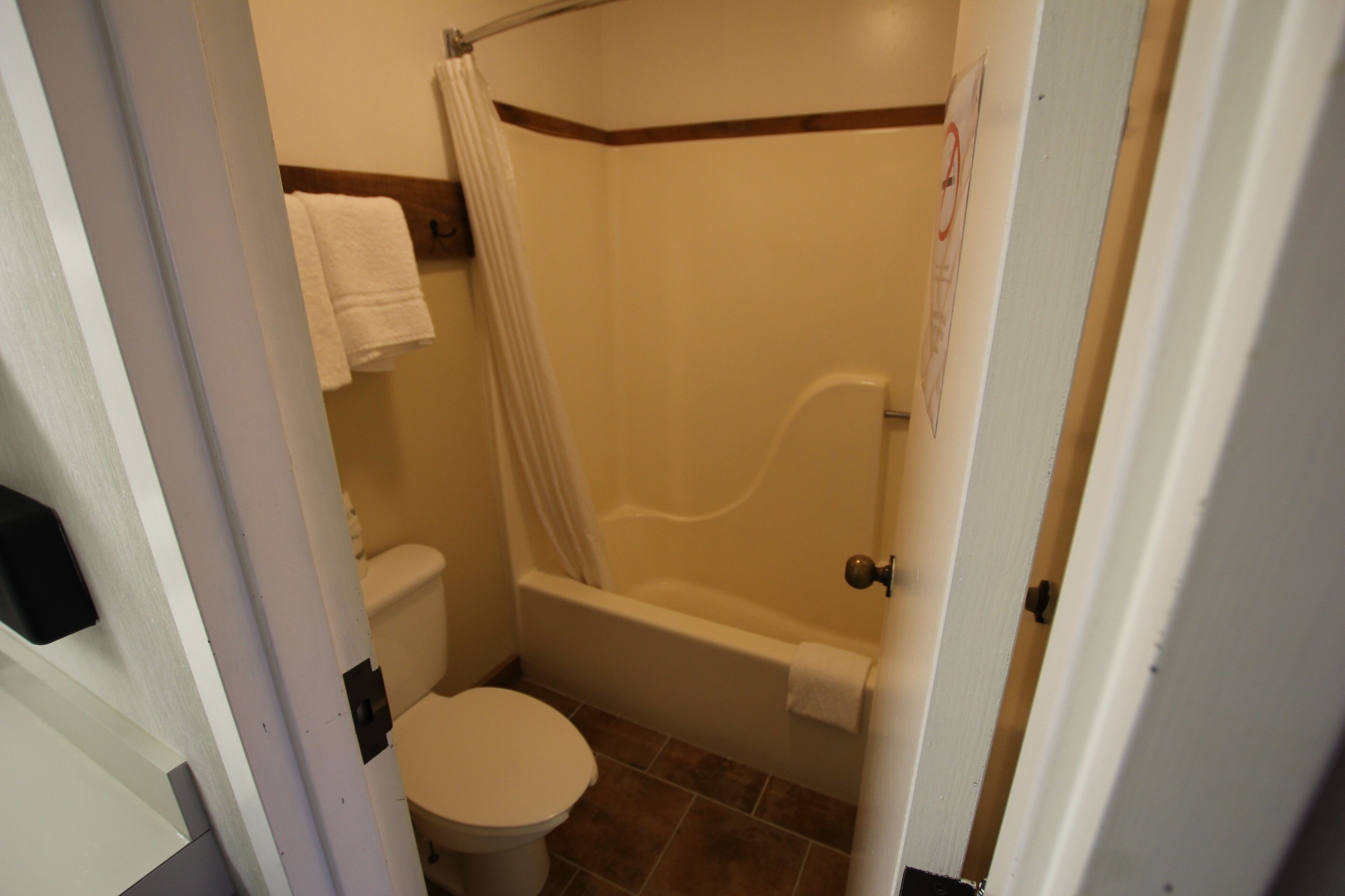 A bathroom with a toilet, a bathtub, and a shower curtain.