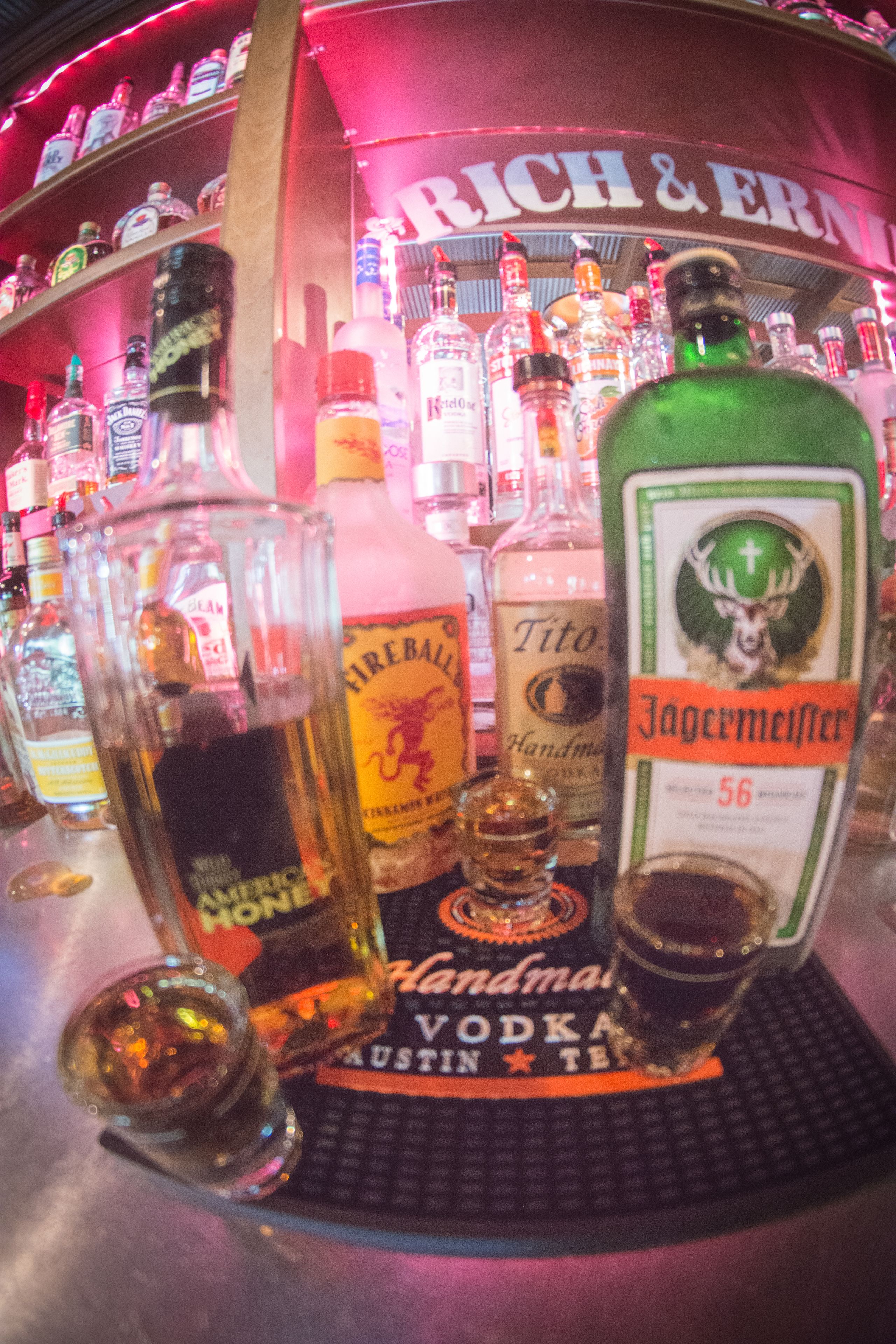 A bar with various liquor bottles and a sign reading "Rich & Ern".