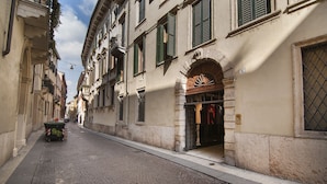 A narrow cobblestone street lined with historic buildings, featuring a mix of architectural styles and a visible number '4' sign. - Dimore Verona (Verona)