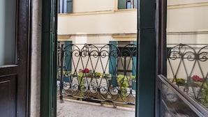 A view through a wrought iron gate into a courtyard with a building in the background. - Dimore Verona (Verona)
