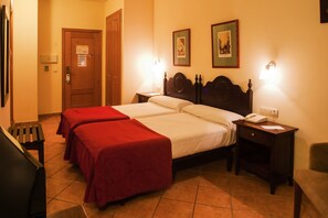 A hotel room with two beds, a desk, a chair, and a door. - Hotel Telecabina (Monachil)