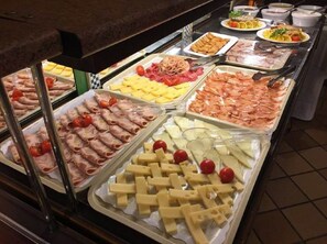 A buffet with various food items including meats, cheeses, and vegetables. - Hotel Telecabina (Monachil)
