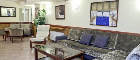 A spacious living area with a sofa, armchairs, and a coffee table.