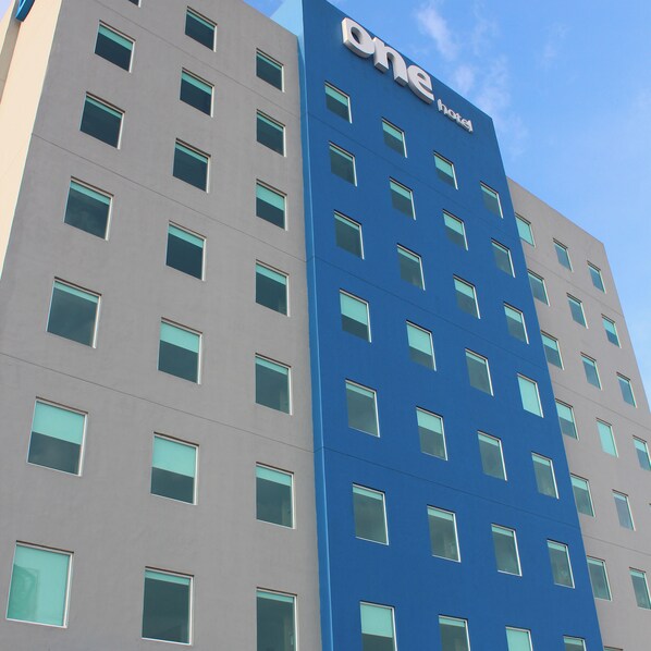 Un hotel moderno con fachada azul y numerosas ventanas.