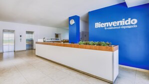 Un mostrador de recepción con una pared azul y un reloj encima.