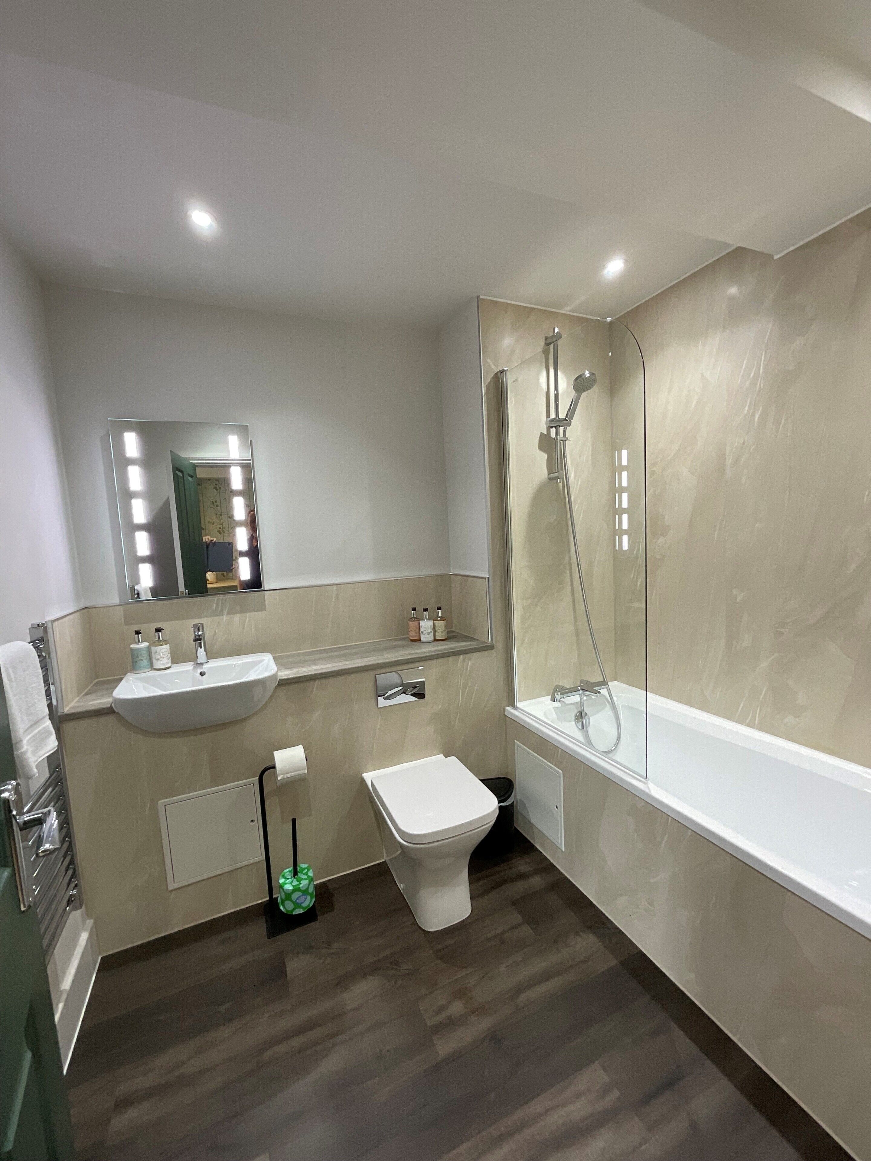 Un bagno moderno con lavandino, WC e doccia.